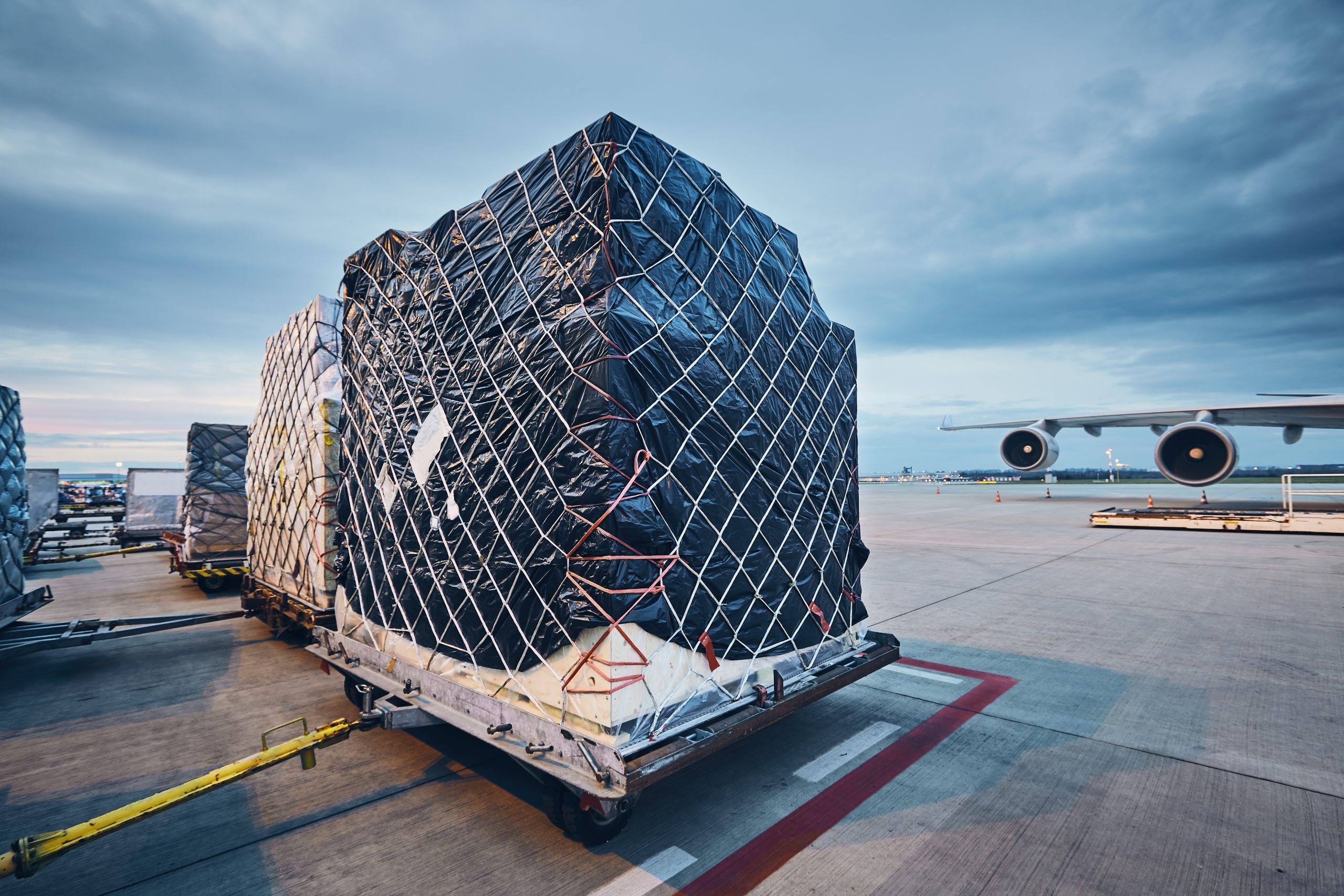 Airport at dusk. Loading of airplane before flight. Loading cargo to airplane