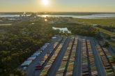 Large cargo container yard with numerous freight containers arranged in rows, showcasing logistics operations under a sunset sky, emphasizing Smith Transport Solutions
