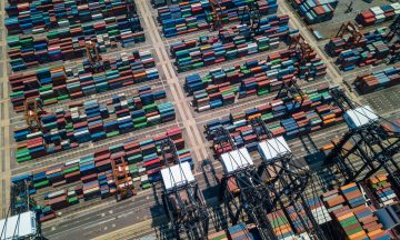 Aerial view of Kwai Tsing container terminals in Hong Kong, showcasing rows of colorful shipping containers and cargo handling equipment, illustrating logistics and supply chain operations.