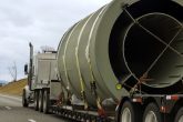 Large truck transporting oversized cylindrical goods on a highway, showcasing logistics capabilities for bulky cargo transport.